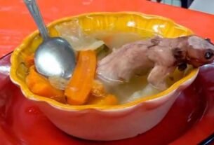 Tigela contendo um rato inteiro ensopado com cenoura e outros legumes.